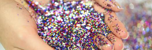 Hands holding loose glitter.